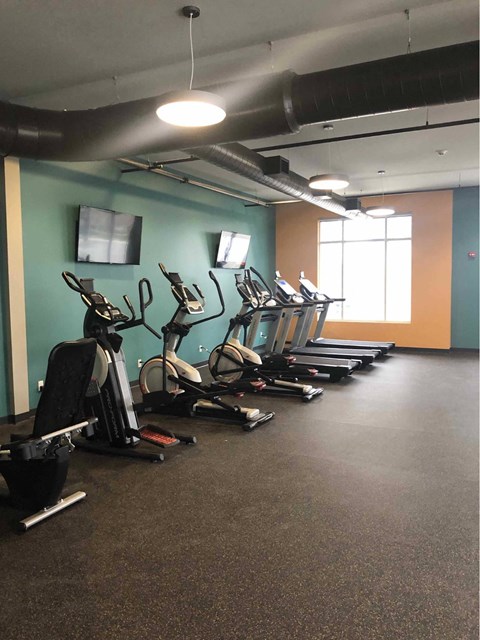 a gym with a row of exercise bikes at The Pomenade at Founders Square Apartments in Portage, IN