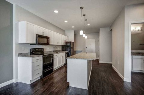 an empty kitchen with white cabinets and a counter top