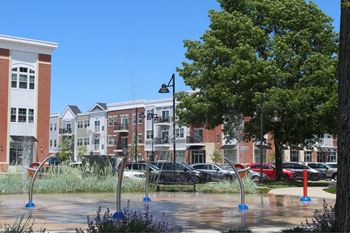a fountain in a park in front of some buildings