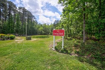 A sign that says Central Bark stands in a grassy area.