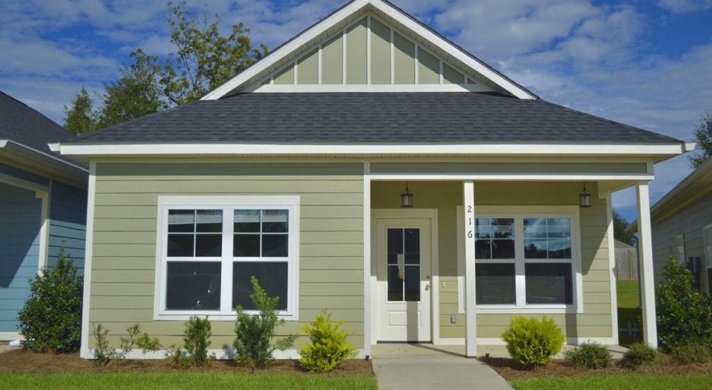 A small house with a grey roof and a white door.