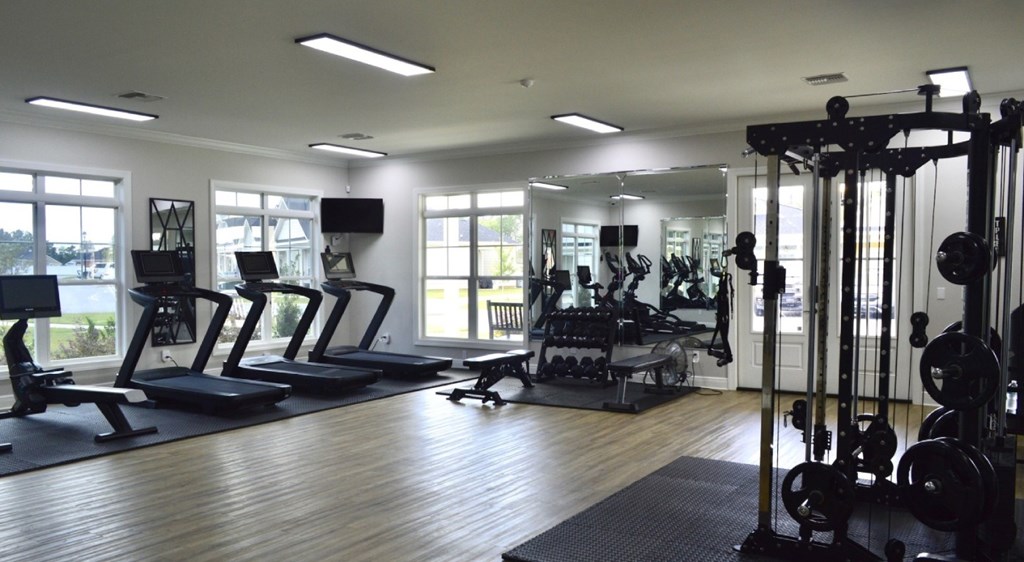 A gym with treadmills, weights, and exercise equipment.