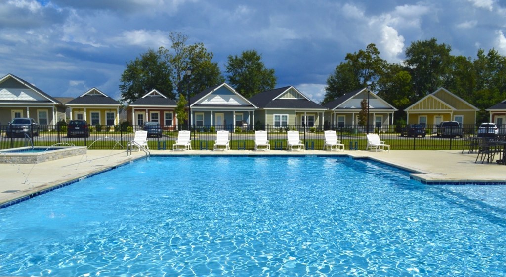 A swimming pool in front of a row of houses.