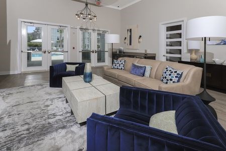 A living room with a blue couch and a white coffee table.