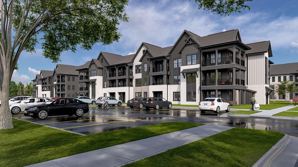 A row of houses with cars parked in front.