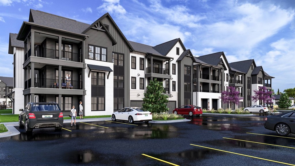 A row of modern townhouses with cars parked in front.