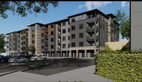 A modern apartment building with a parking lot in front.