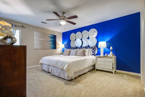 A bedroom with a white bed and a blue wall.