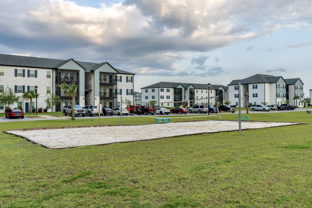 a grassy area with several apartment buildings in the background