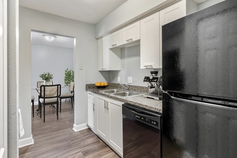 a kitchen with black appliances and white cabinets