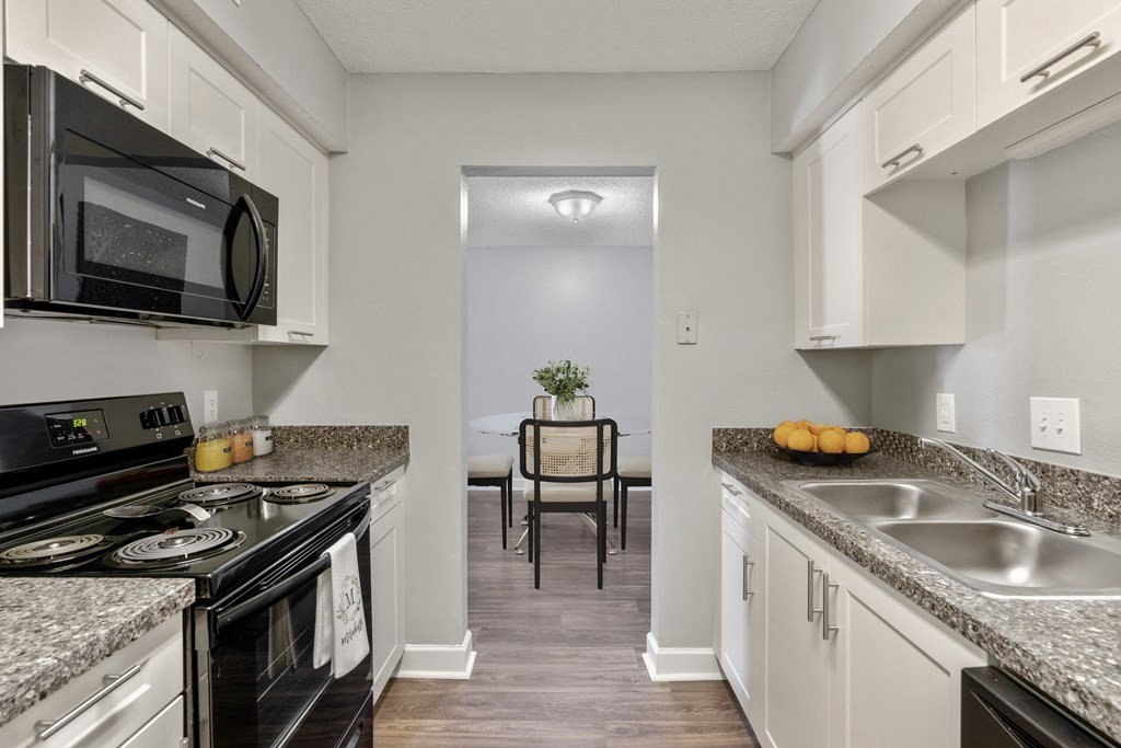 Kitchen with white cabinets and granite countertops  at Mirabelle Apartments in Mobile, Alabama