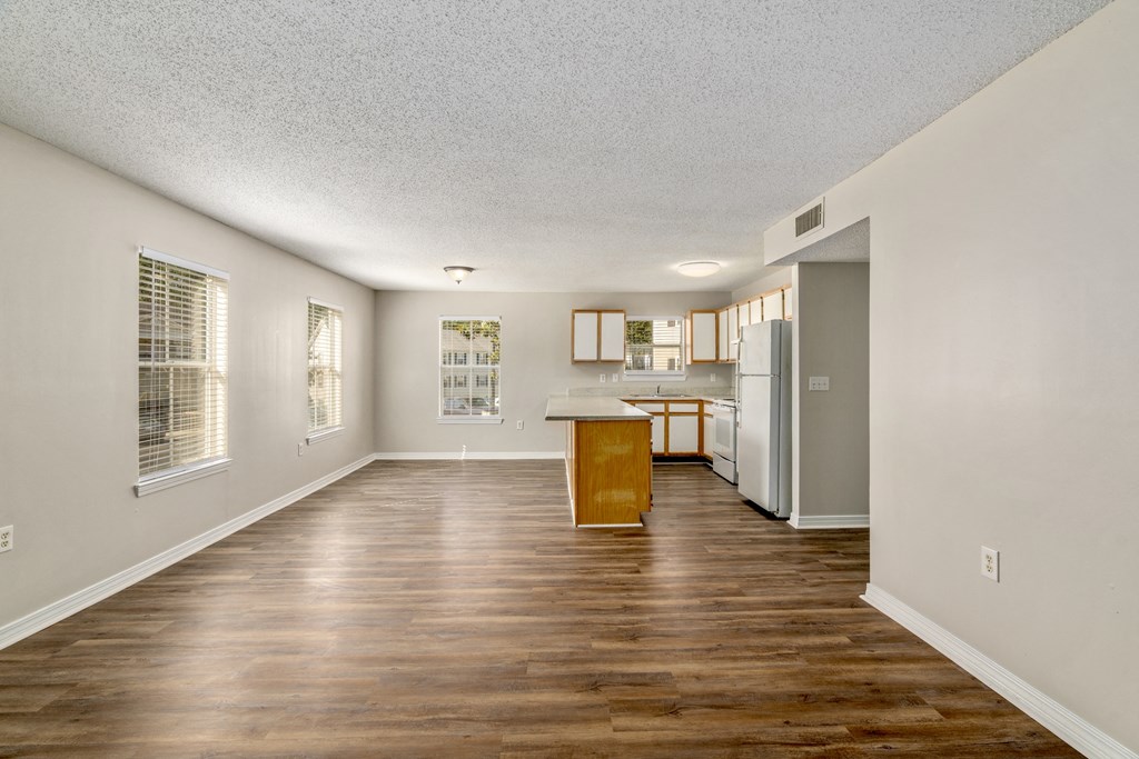 a living and kitchen area with hardwood floors and white walls