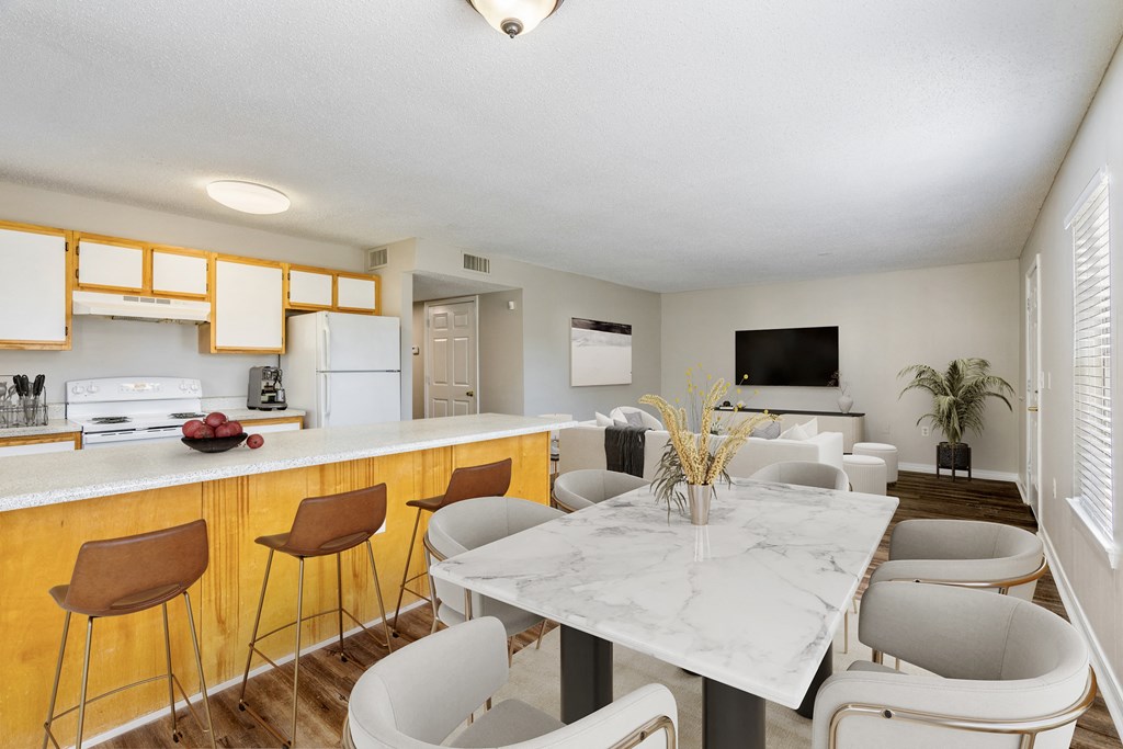 a kitchen with a long counter and a table with chairs