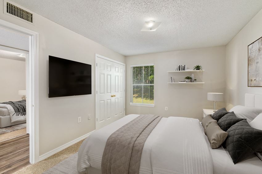 a bedroom with a large bed and a flat screen tv