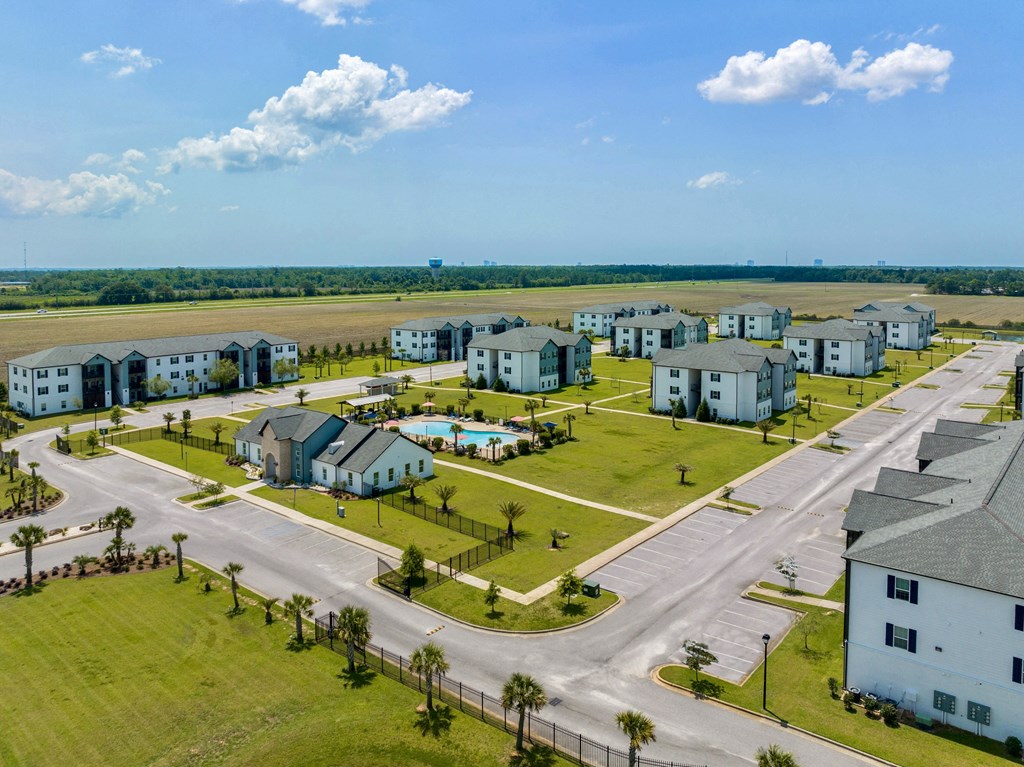 an aerial view of a housing complex with a runway in the background