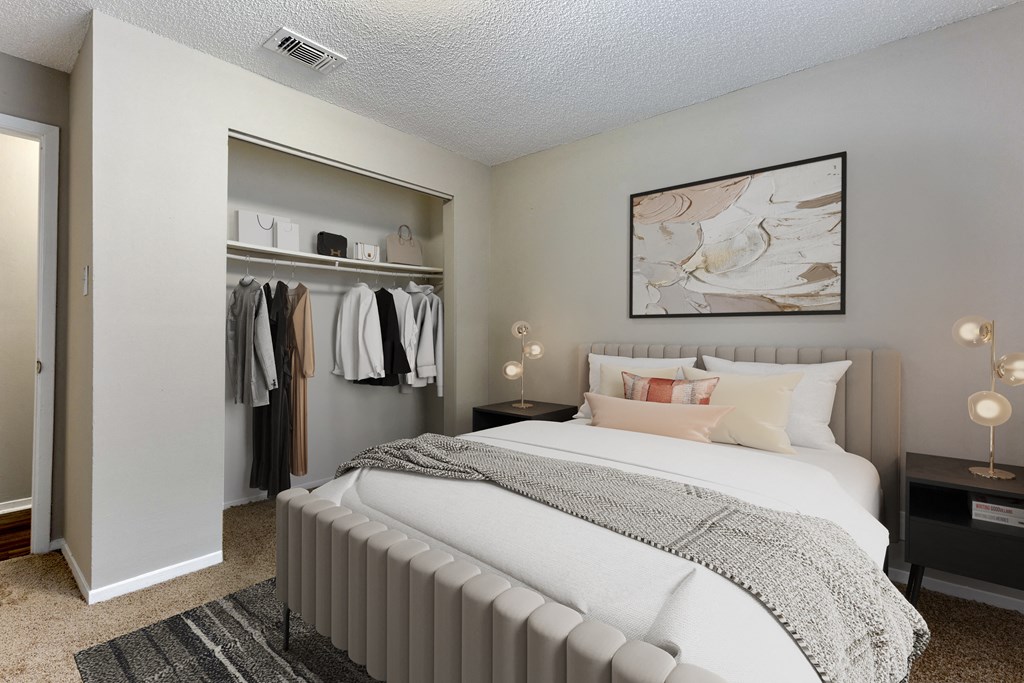 a bedroom with a large bed and a closet with a mirrored door
