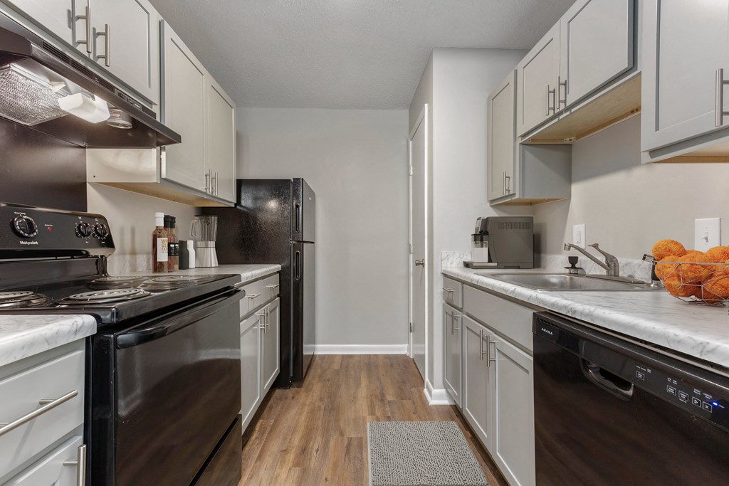 a kitchen with white cabinets and black appliances