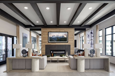 A modern living room with a fireplace and a large painting above it.