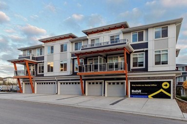 A modern multi-story building with a black and yellow logo on the ground.
