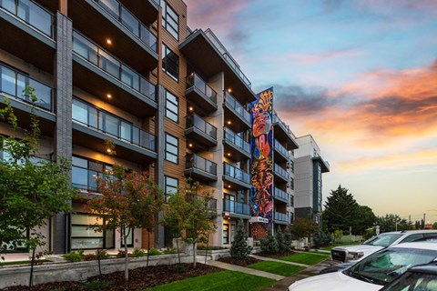 A modern apartment building with a colorful mural on the side.