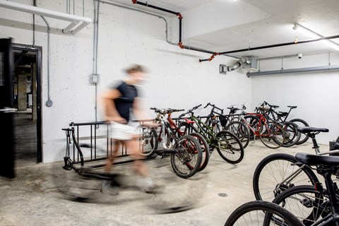 A person is running in a room full of bicycles.