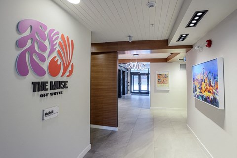 A hallway with a sign that says "The Muse" on the wall.