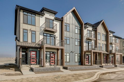 A row of modern townhouses with balconies and garages.
