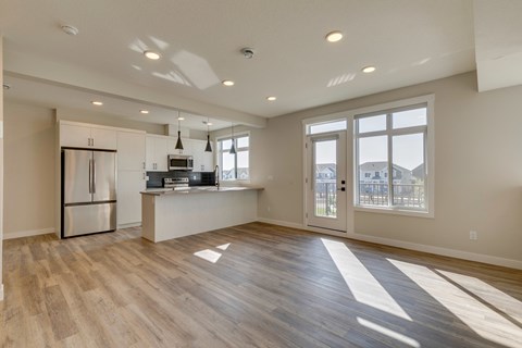 A kitchen with a refrigerator, microwave, and oven is shown.