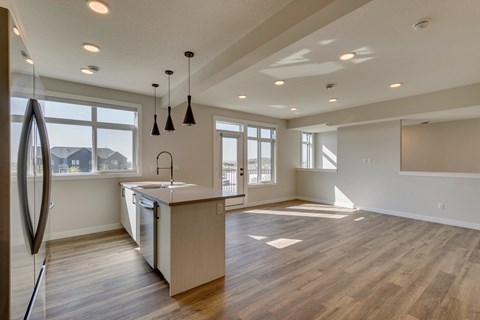 A modern kitchen with wooden floors and a large island.