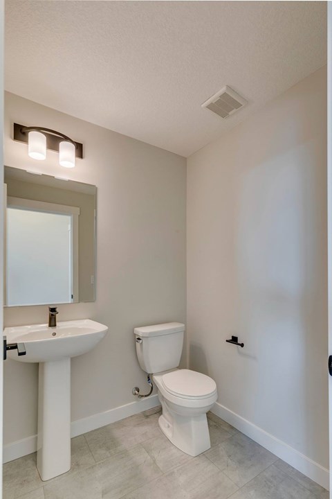 A white sink and toilet in a small bathroom.