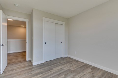A room with two white doors and a wooden floor.