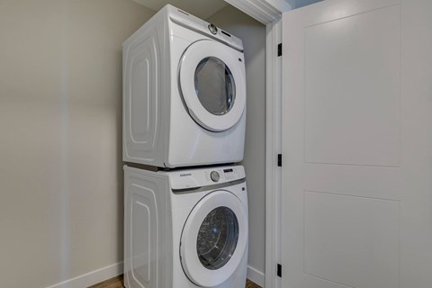 Two white front loading washing machines in a laundry room.