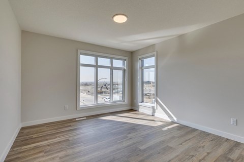 A room with a large window and wooden flooring.