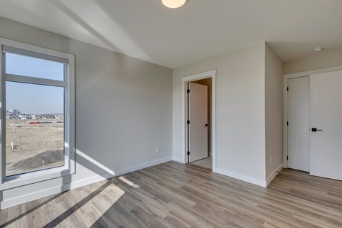 A room with a large window and wooden flooring.