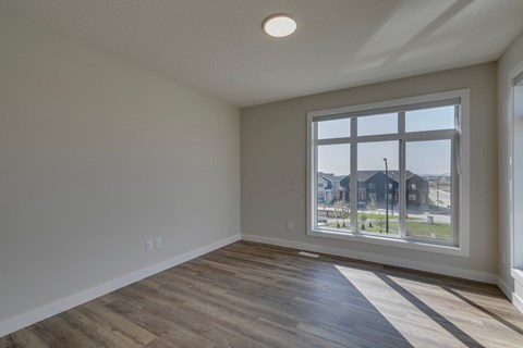A room with a large window and wooden flooring.