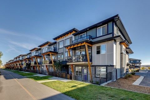 a row of modern apartments with balconies on the side of a street