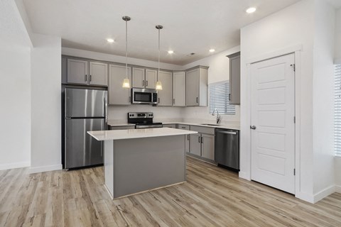a renovated kitchen with stainless steel appliances and a white counter top