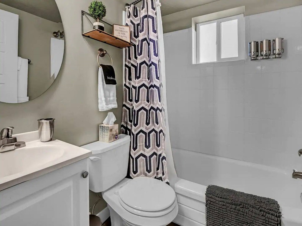 a bathroom with a toilet and a tub and a sink