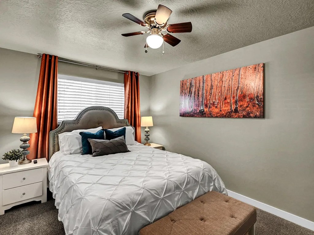 a bedroom with a bed and a ceiling fan