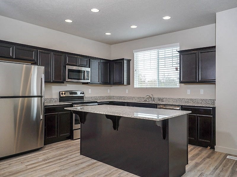 a kitchen with stainless steel appliances and black cabinets