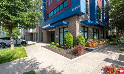 Modern apartment building entrance with landscaping at The Mark at Midtown Apartments, Dallas, TX