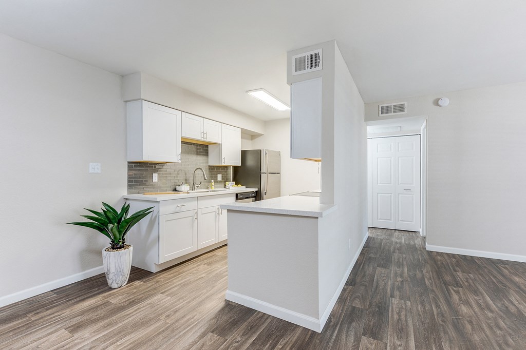 an open kitchen with white cabinets and a plant in a vase at Stonebridge, Phoenix, AZ