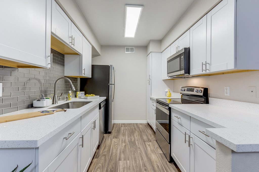 a renovated kitchen with white cabinets and stainless steel appliances at Stonebridge, Phoenix, AZ, 85032