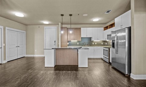 Open kitchen with island and stainless steel appliances at Matilda at Lower Greenville Apartments, Dallas
