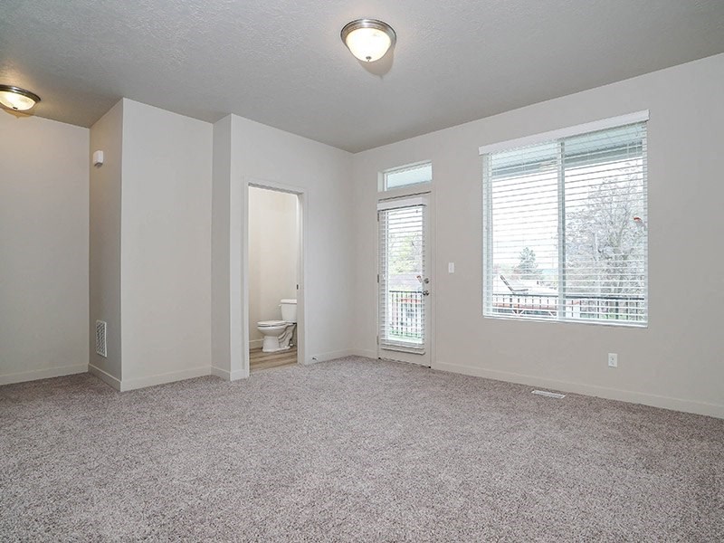 an empty living room with a toilet and a window