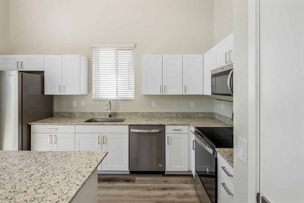 a kitchen with white cabinets and granite countertops