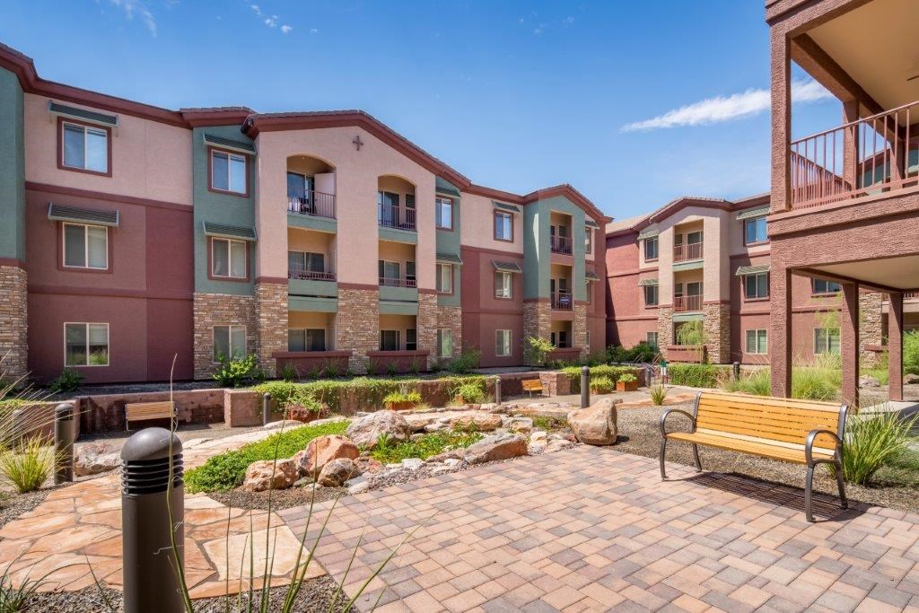 A row of apartment buildings with a bench in front of them.