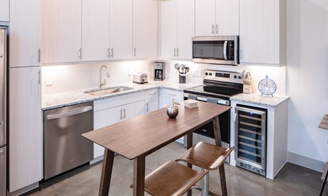 A kitchen with a table and chairs.