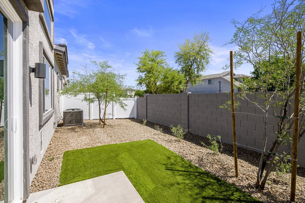 a backyard with a grassy area and a fence