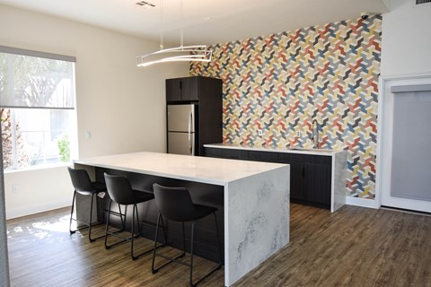 a kitchen with a marble counter top and black cabinets